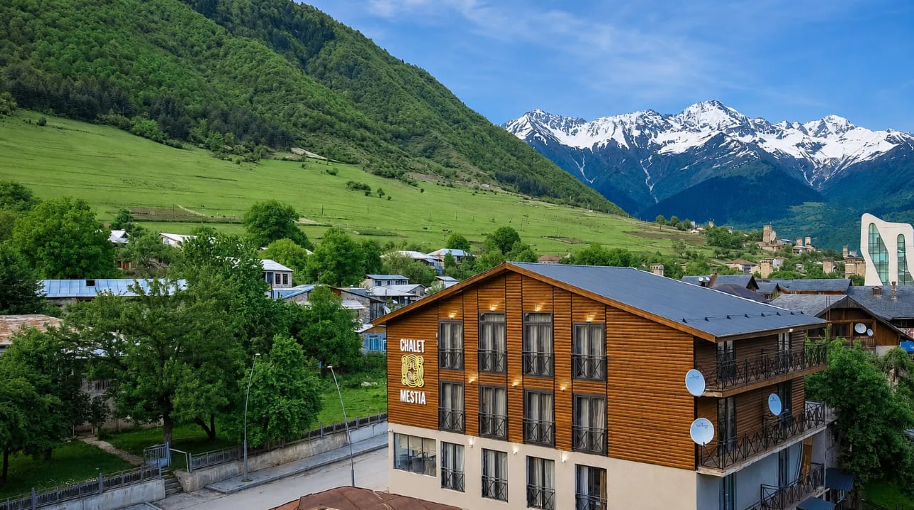 Aerial view of Chalet Mestia with the snow-capped Caucasus behind