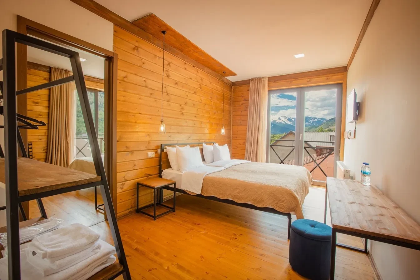 Wood-panelled room with a window framing snow-capped mountains
